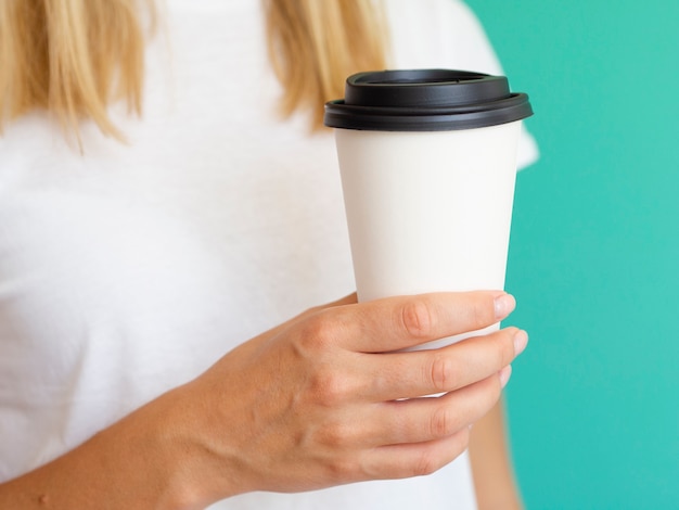 Free photo close-up woman with coffee cup and green background