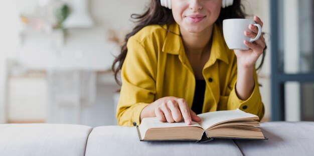 Close-up woman with cup and headphones