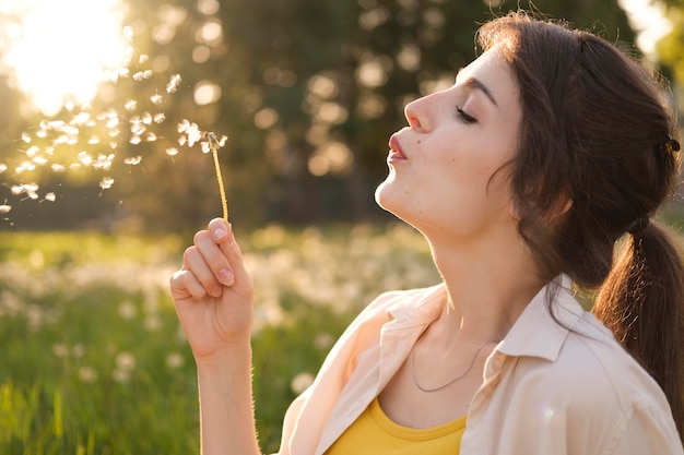 Close up woman with dandelion outdoors