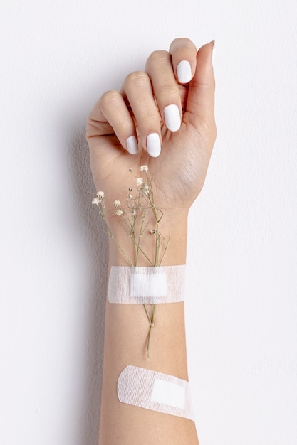 Close-up woman with flowers and band-aids