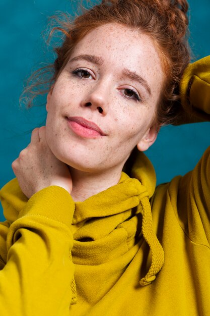 Close-up woman with freckles and yellow hoodie