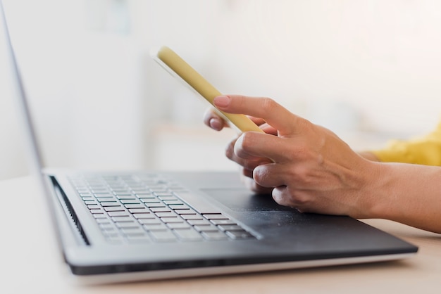 Free photo close-up woman with laptop and smartphone