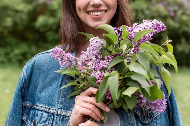 Close-up woman with lilac bouquet