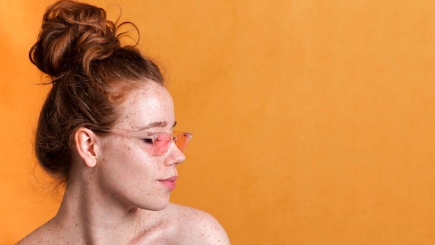 Close-up woman with pink glasses looking away