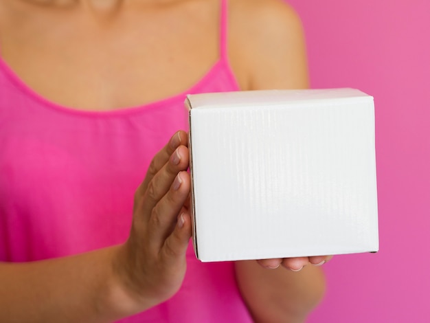 Free photo close-up woman with pink shirt and box