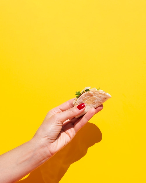 Close-up woman with taco and yellow background