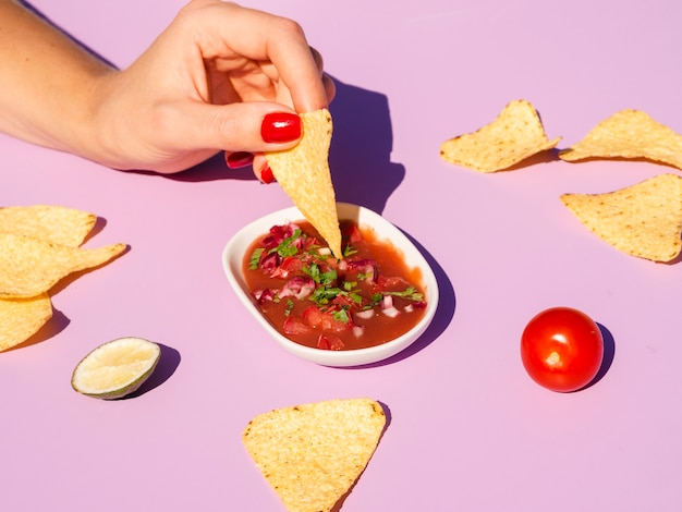 Free Photo close-up woman with tortilla chips and sauce