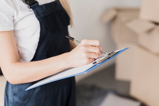 Close-up woman writing on clipboard