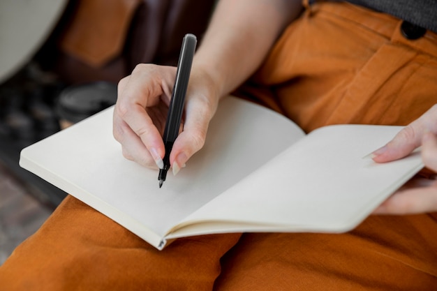 Free photo close-up woman writing in journal