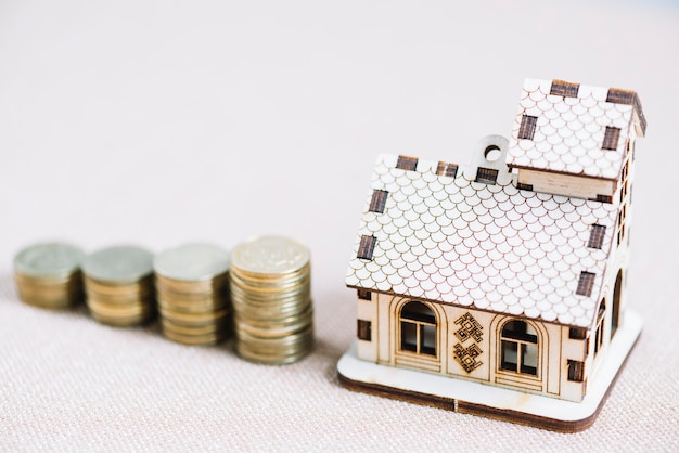 Free photo close-up wooden house near stacks of coins