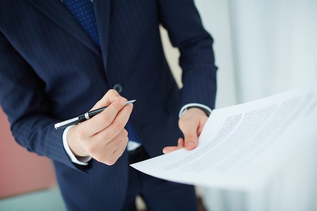 Free Photo close-up of worker reading the contract before signing