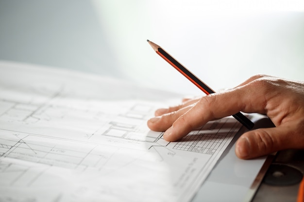 Close up of worker's hand on drawing.