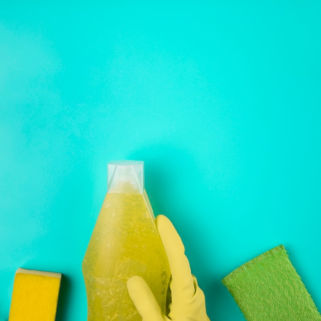 Free photo close-up yellow glove with detergent and sponges