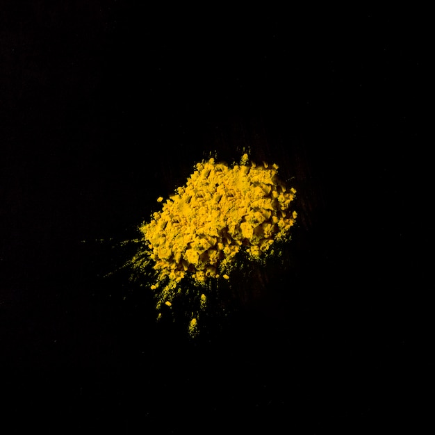 Free photo close-up of a yellow holi color on black surface