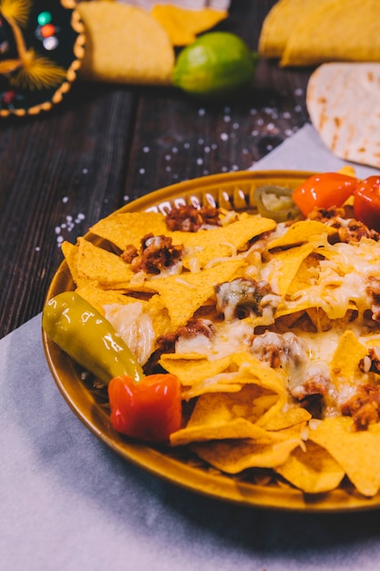 Free photo close-up of yellow mexican nachos in plate on butter paper