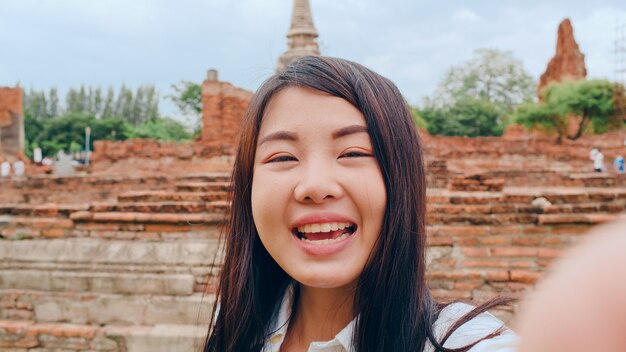 Close-up Young Asian backpacker blogger woman looks at front on smartphone