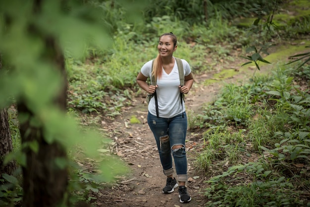 Close up of young backpacker walking through the forest happy with nature. Travel concept.