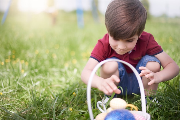 Close up on young boy looking at colorful Easter eggs