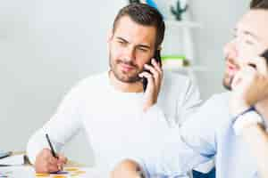 Free photo close-up of a young businessman talking on cellphone