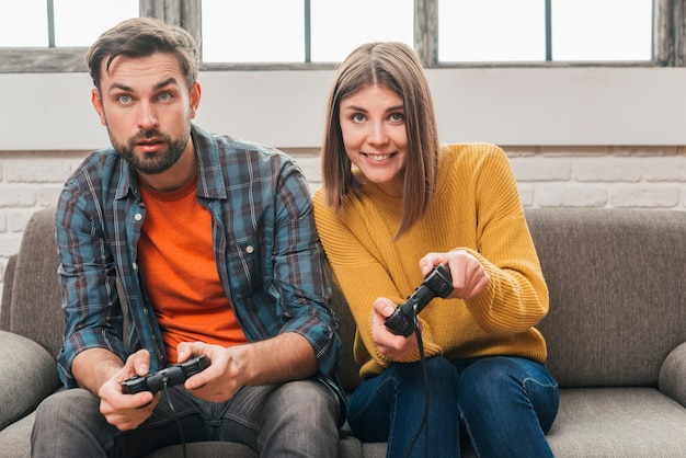 Free Photo close-up of young couple playing the video game with joystick