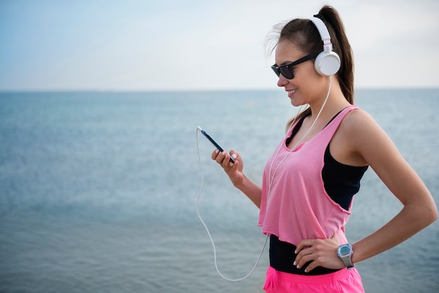 Free photo close up on young fit person jogging by the sea