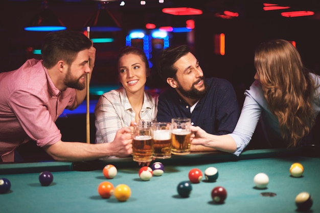 Free photo close up on young friends having fun while playing pool game