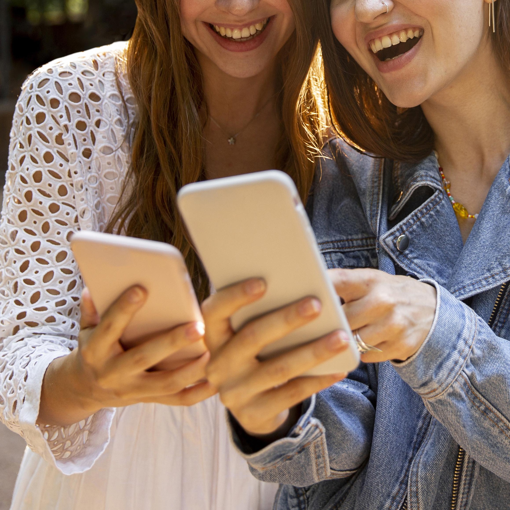 Close-up young girlfriends with mobile