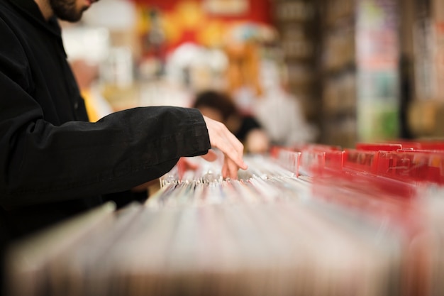 Close-up young man looking for vinyls in store