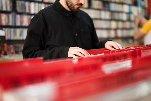 Close-up young man looking for vinyls in store