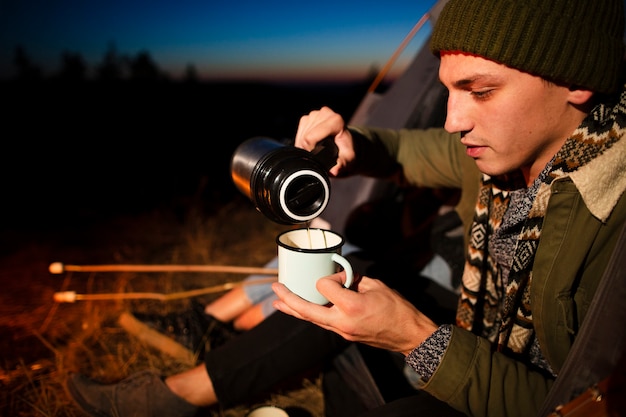 Free photo close-up young man pouring a hot drink