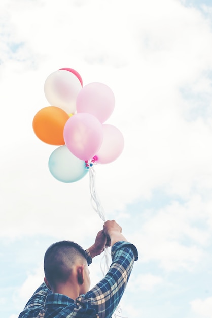 Free photo close-up of young man with balloons in hands