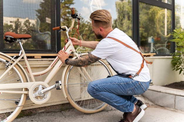 Free photo close up on young man working on a bike