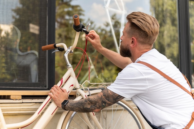 Free photo close up on young man working on a bike