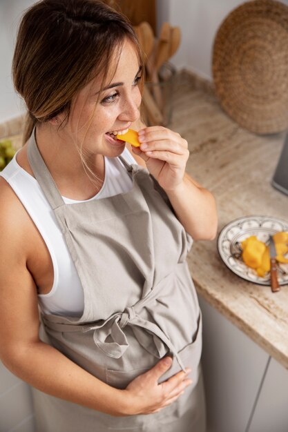 Close up on young pregnant woman cooking