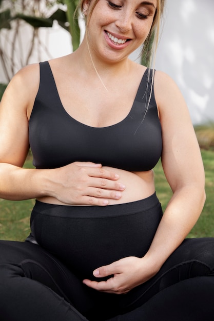 Free Photo close up on young pregnant woman doing yoga