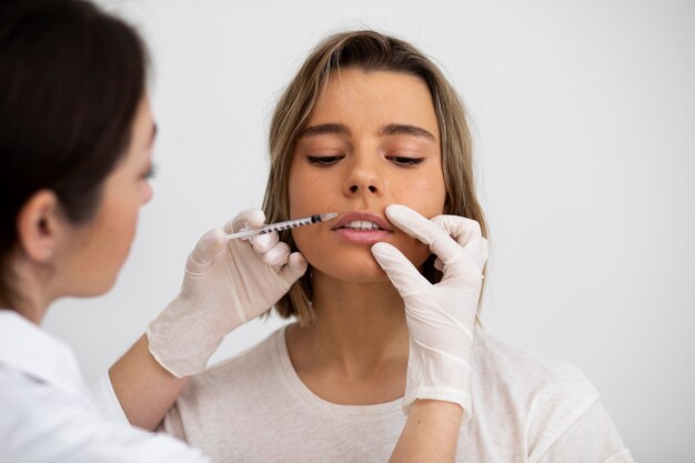 Close up young woman getting lip filler