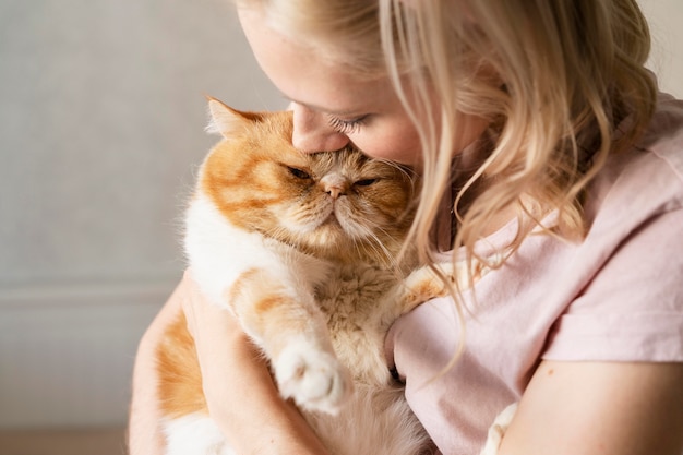 Close up young woman kissing cute cat