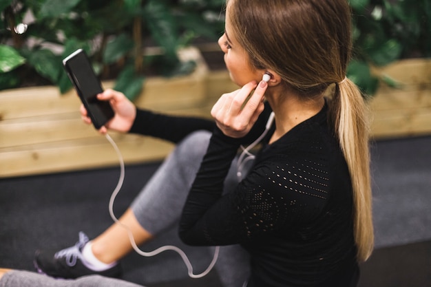 Free photo close-up of a young woman listening to music in gym