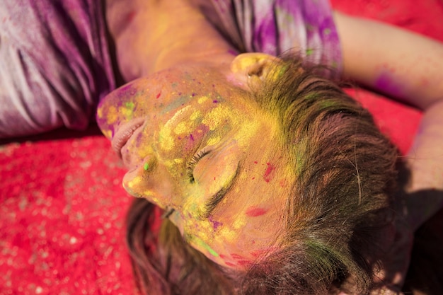 Free photo close-up of a young woman's face covered with holi color