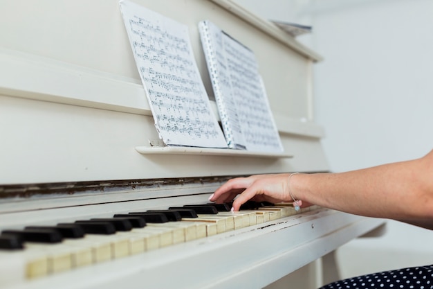 Free photo close-up of young woman's hand playing the piano