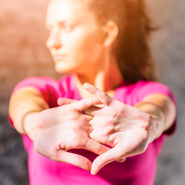 Close-up of a young woman stretching her hands