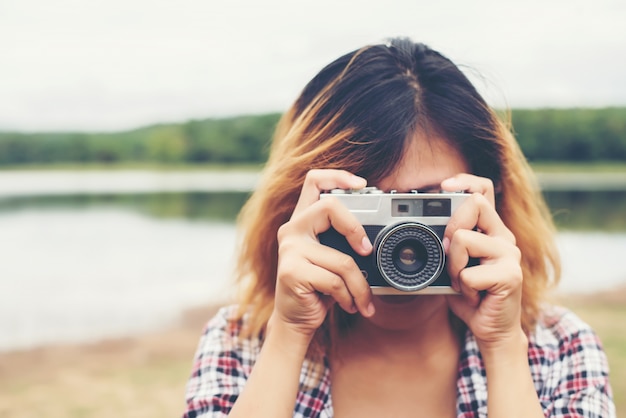 Free photo close-up of young woman using her vintage camera