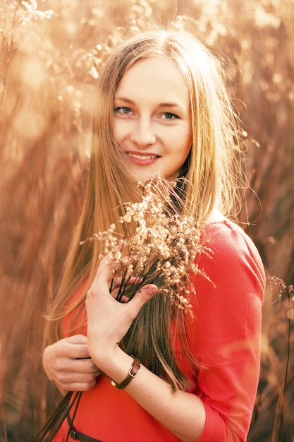 Close-up of young woman with red dress holding a bouquet