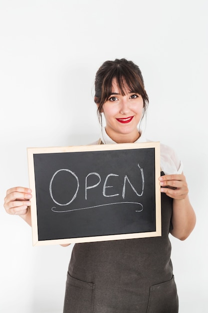 Close-up of a young woman with slate showing open word