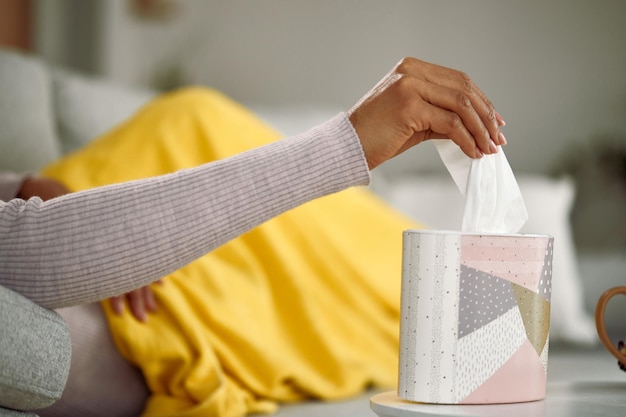 Closeup of African American woman taking tissue from a box