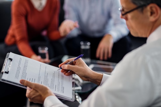 Closeup of agent going through lease agreement while having a meeting with his clients