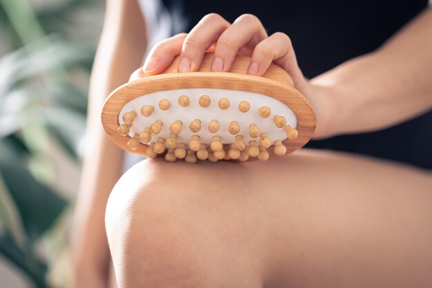 Closeup of anticellulite massage brush in female hands