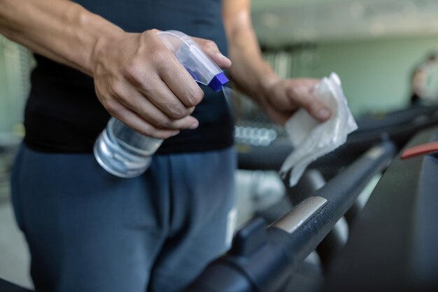 Closeup of athlete disinfecting running track in a gym