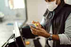 Free photo closeup of auto mechanic disinfecting smart phone while working in the office at repair shop