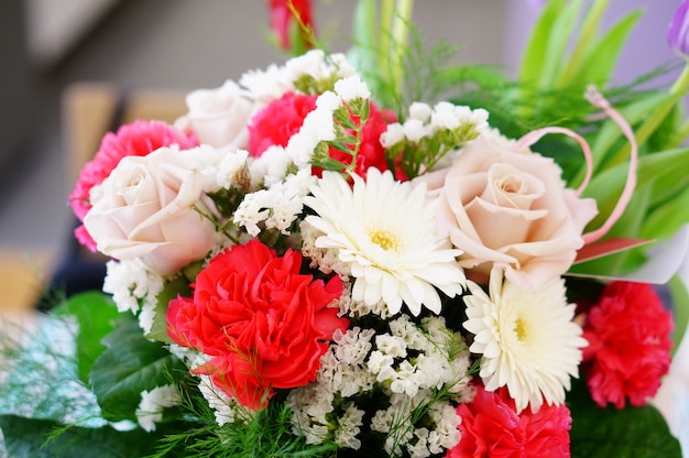 Closeup of a beautiful bouquet of flowers composed of roses, statice, carnation and daisies